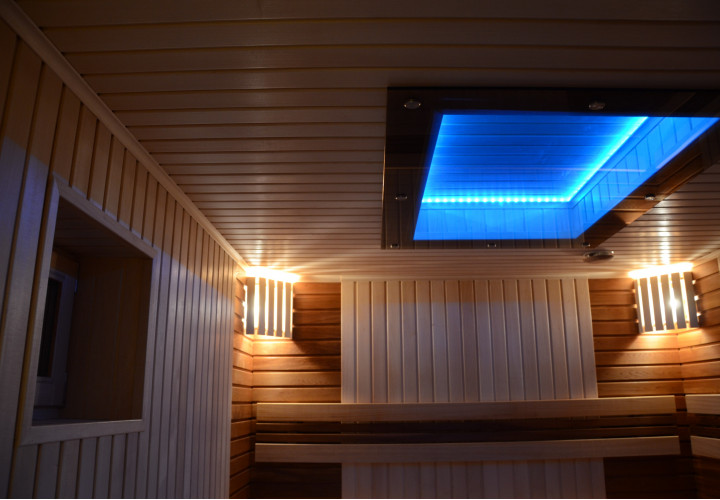Sauna s dřevěnými kamny a skleněným stropem