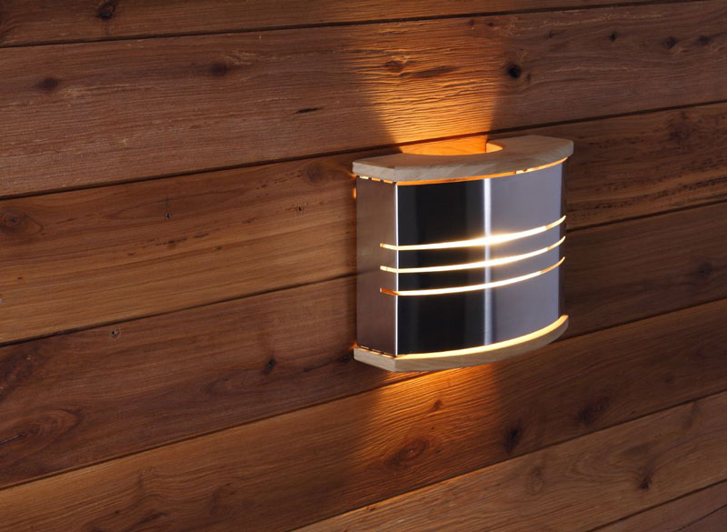 Nástěnná saunová lampa vyrobená z kovu a dřeva na stěnu sauny.